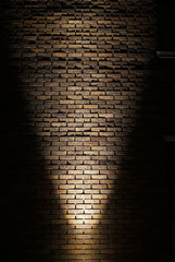 Light shining on brick wall at night