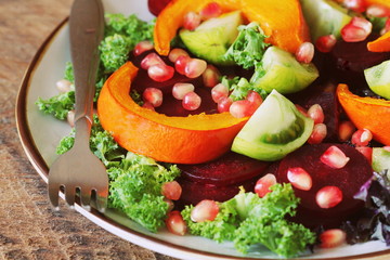Healthy vegetarian salad, roasted pumpkin, tomato,pomegranate, kale, beet