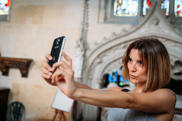 Young girl doing a selfie with the mobile in a church