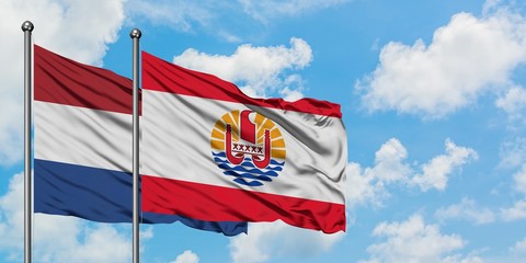 Netherlands and French Polynesia flag waving in the wind against white cloudy blue sky together. Diplomacy concept, international relations.
