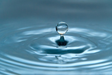 a drop of water hovering in the air before hitting a water surface, which will cause a beautiful splash, close-up photo