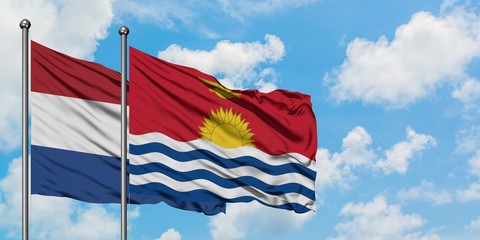 Netherlands and Kiribati flag waving in the wind against white cloudy blue sky together. Diplomacy concept, international relations.