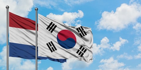 Netherlands and South Korea flag waving in the wind against white cloudy blue sky together. Diplomacy concept, international relations.