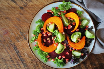 Healthy vegetarian salad, roasted pumpkin, tomato,pomegranate, kale, beet