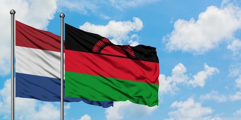 Netherlands and Malawi flag waving in the wind against white cloudy blue sky together. Diplomacy concept, international relations.