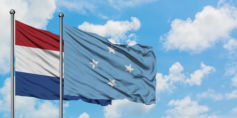 Netherlands and Micronesia flag waving in the wind against white cloudy blue sky together. Diplomacy concept, international relations.