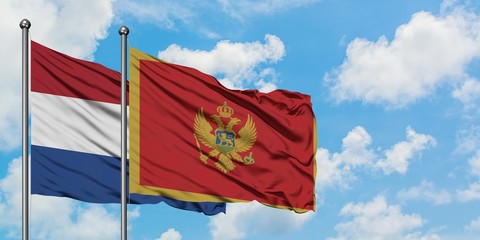 Netherlands and Montenegro flag waving in the wind against white cloudy blue sky together. Diplomacy concept, international relations.