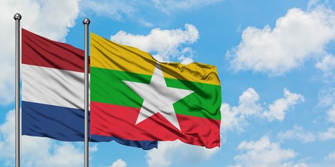Netherlands and Myanmar flag waving in the wind against white cloudy blue sky together. Diplomacy concept, international relations.
