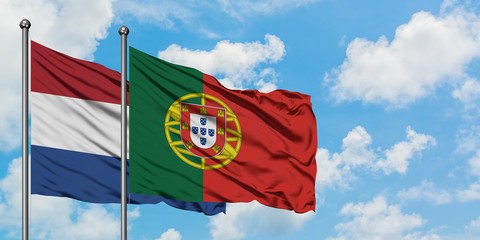 Netherlands and Portugal flag waving in the wind against white cloudy blue sky together. Diplomacy concept, international relations.