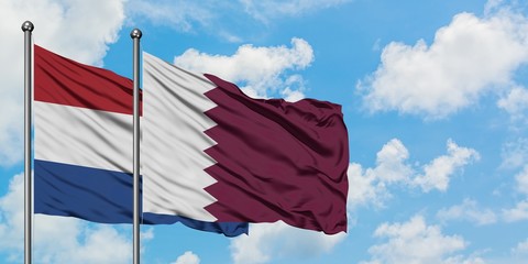 Netherlands and Qatar flag waving in the wind against white cloudy blue sky together. Diplomacy concept, international relations.