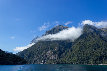 Milford Sound on a ferry on a beautiful blue sky day, Fiordland, South Island,New Zealand.