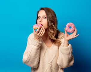 Style woman in sweater with donut on blue background