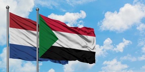 Netherlands and Sudan flag waving in the wind against white cloudy blue sky together. Diplomacy concept, international relations.