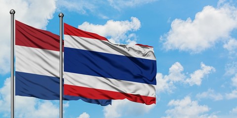 Netherlands and Thailand flag waving in the wind against white cloudy blue sky together. Diplomacy concept, international relations.