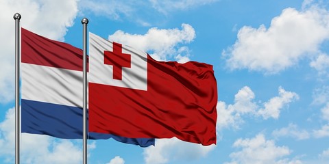 Netherlands and Tonga flag waving in the wind against white cloudy blue sky together. Diplomacy concept, international relations.