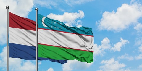 Netherlands and Uzbekistan flag waving in the wind against white cloudy blue sky together. Diplomacy concept, international relations.