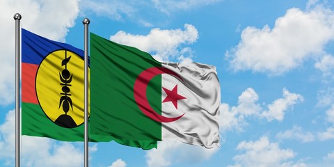 New Caledonia and Algeria flag waving in the wind against white cloudy blue sky together. Diplomacy concept, international relations.