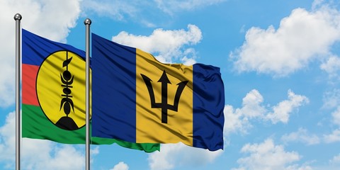 New Caledonia and Barbados flag waving in the wind against white cloudy blue sky together. Diplomacy concept, international relations.