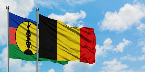 New Caledonia and Belgium flag waving in the wind against white cloudy blue sky together. Diplomacy concept, international relations.