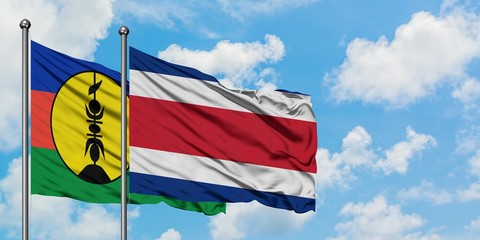 New Caledonia and Costa Rica flag waving in the wind against white cloudy blue sky together. Diplomacy concept, international relations.