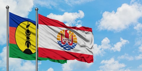 New Caledonia and French Polynesia flag waving in the wind against white cloudy blue sky together. Diplomacy concept, international relations.