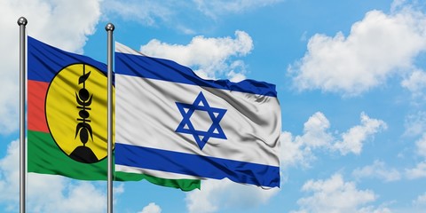 New Caledonia and Israel flag waving in the wind against white cloudy blue sky together. Diplomacy concept, international relations.