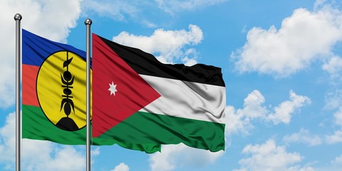 New Caledonia and Jordan flag waving in the wind against white cloudy blue sky together. Diplomacy concept, international relations.