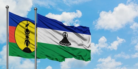 New Caledonia and Lesotho flag waving in the wind against white cloudy blue sky together. Diplomacy concept, international relations.