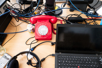 Rotes Wählscheibentelefon auf Schreibtisch