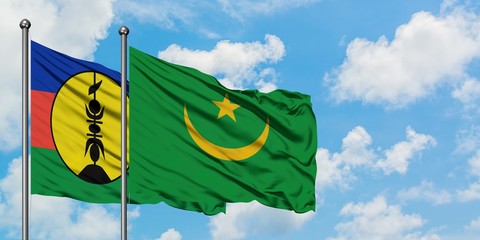 New Caledonia and Mauritania flag waving in the wind against white cloudy blue sky together. Diplomacy concept, international relations.