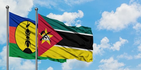 New Caledonia and Mozambique flag waving in the wind against white cloudy blue sky together. Diplomacy concept, international relations.