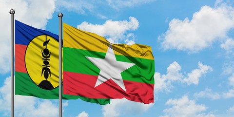 New Caledonia and Myanmar flag waving in the wind against white cloudy blue sky together. Diplomacy concept, international relations.