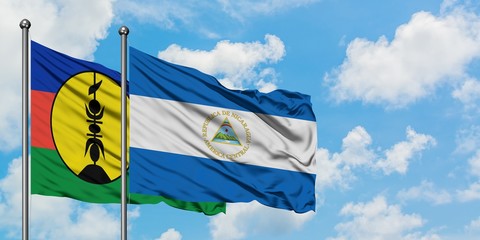 New Caledonia and Nicaragua flag waving in the wind against white cloudy blue sky together. Diplomacy concept, international relations.