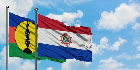 New Caledonia and Paraguay flag waving in the wind against white cloudy blue sky together. Diplomacy concept, international relations.