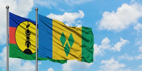 New Caledonia and Saint Vincent And The Grenadines flag waving in the wind against white cloudy...