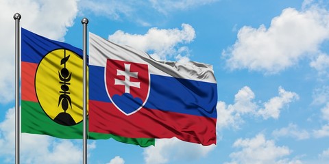 New Caledonia and Slovakia flag waving in the wind against white cloudy blue sky together. Diplomacy concept, international relations.