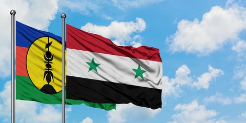 New Caledonia and Syria flag waving in the wind against white cloudy blue sky together. Diplomacy concept, international relations.
