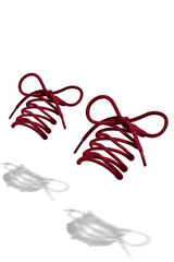 The photo of burgundy wicker round shoelaces with burgundy tips, hanging in the air on a white background. Shoelaces is casting a shadow. 