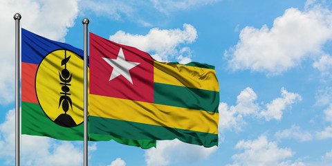 New Caledonia and Togo flag waving in the wind against white cloudy blue sky together. Diplomacy concept, international relations.