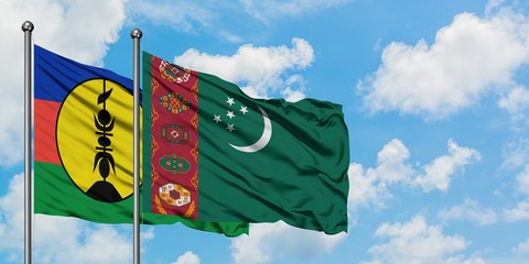 New Caledonia and Turkmenistan flag waving in the wind against white cloudy blue sky together. Diplomacy concept, international relations.