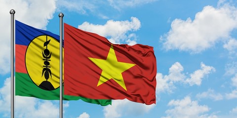 New Caledonia and Vietnam flag waving in the wind against white cloudy blue sky together. Diplomacy concept, international relations.