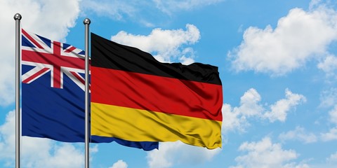 New Zealand and Germany flag waving in the wind against white cloudy blue sky together. Diplomacy concept, international relations.