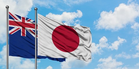 New Zealand and Japan flag waving in the wind against white cloudy blue sky together. Diplomacy concept, international relations.