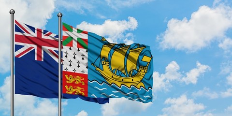 New Zealand and Saint Pierre And Miquelon flag waving in the wind against white cloudy blue sky together. Diplomacy concept, international relations.