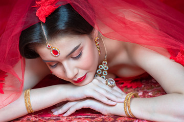 Beautiful portrait of young Asian woman in traditional Hindu red sari wedding clothes with bride dressed makeup and jewelery gorgeous brunette bride. Concept Indian costume