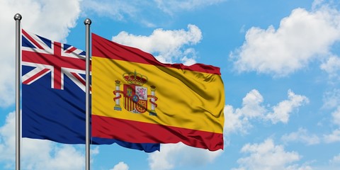 New Zealand and Spain flag waving in the wind against white cloudy blue sky together. Diplomacy concept, international relations.