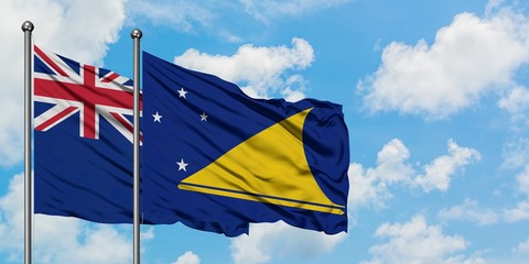 New Zealand and Tokelau flag waving in the wind against white cloudy blue sky together. Diplomacy concept, international relations.