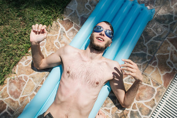man swims in pool near villa