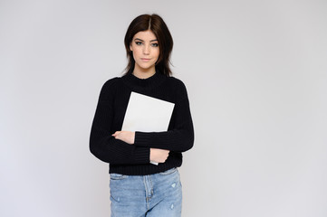 Fototapeta premium Portrait of a young pretty girl student with long black hair, on a white background. He stands right in front of the camera, showing his hands in different poses with different emotions.