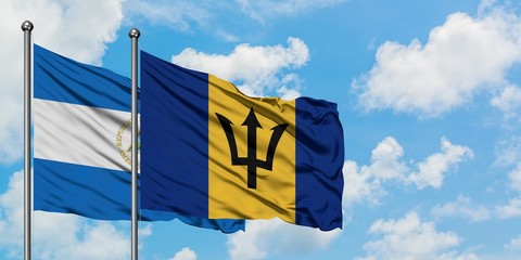 Nicaragua and Barbados flag waving in the wind against white cloudy blue sky together. Diplomacy concept, international relations.